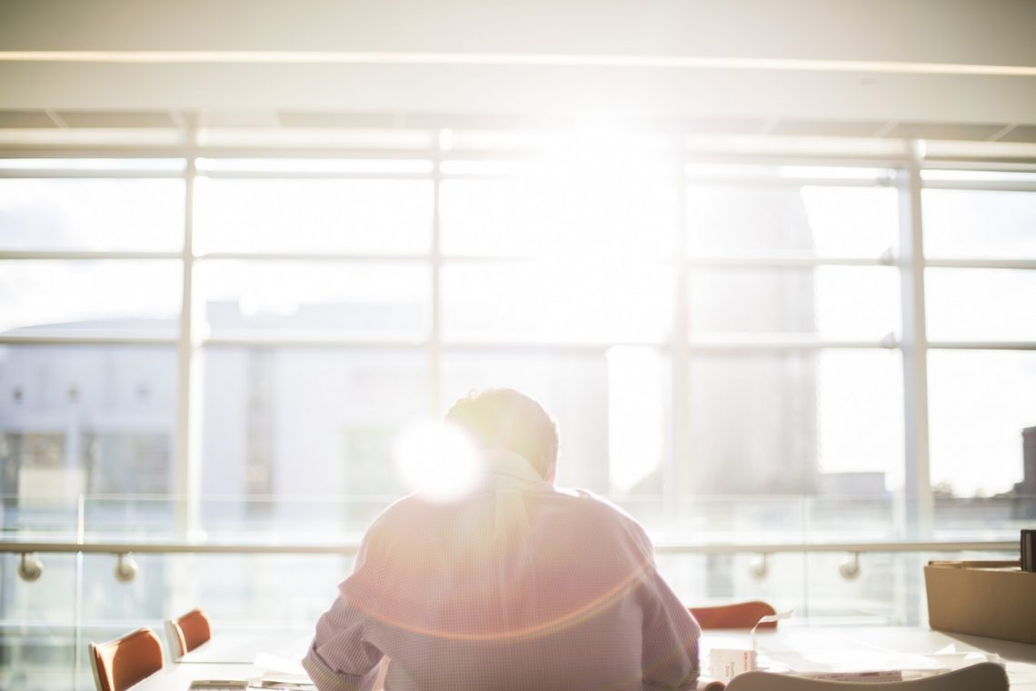 Man in office with sun rising