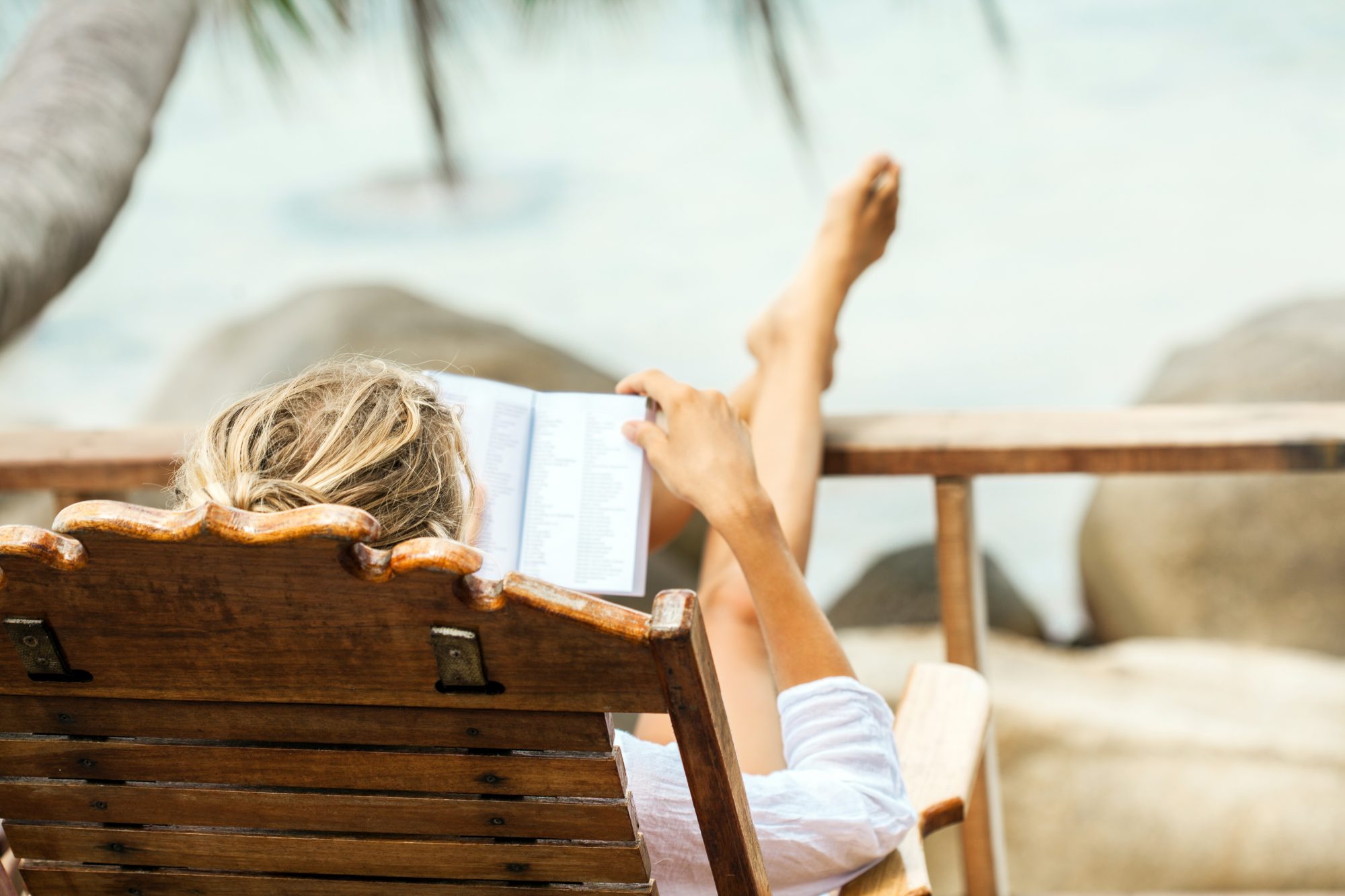 Woman reading a book while relaxing on tropical island. Koh Phangan island, Thailand