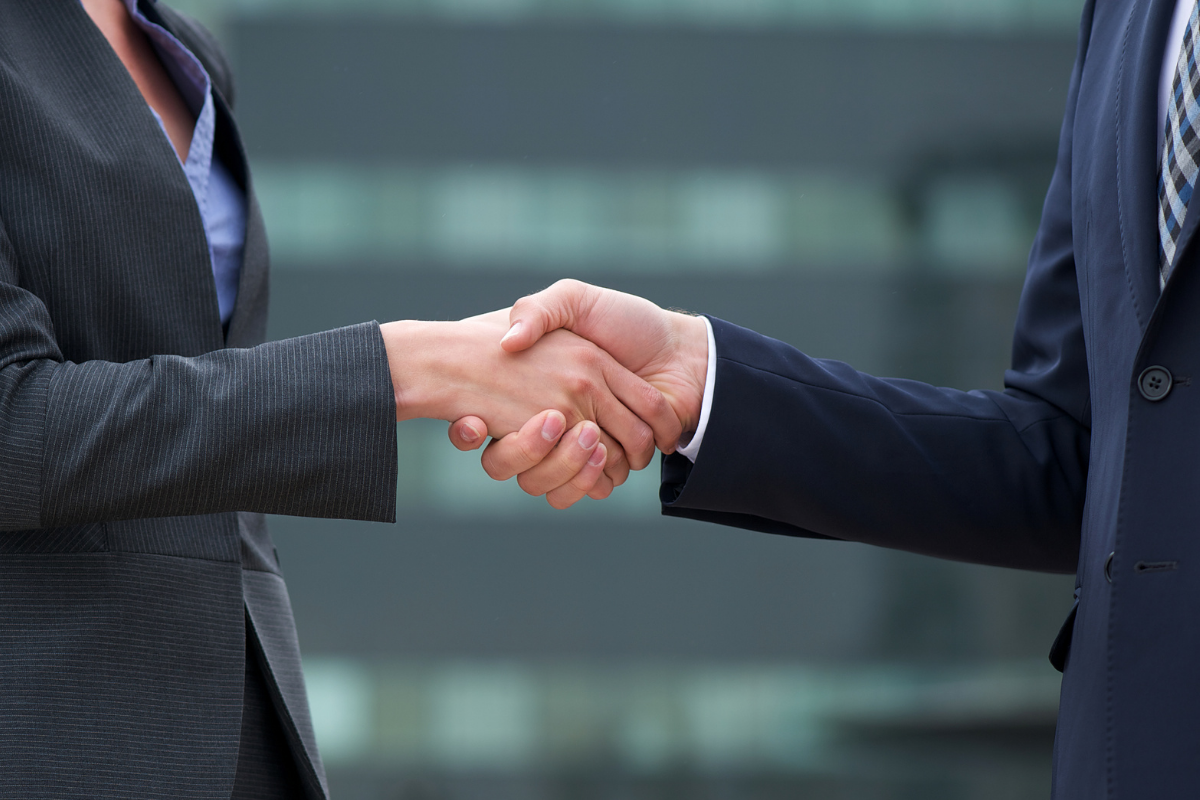 Woman and man in business attire shaking hands