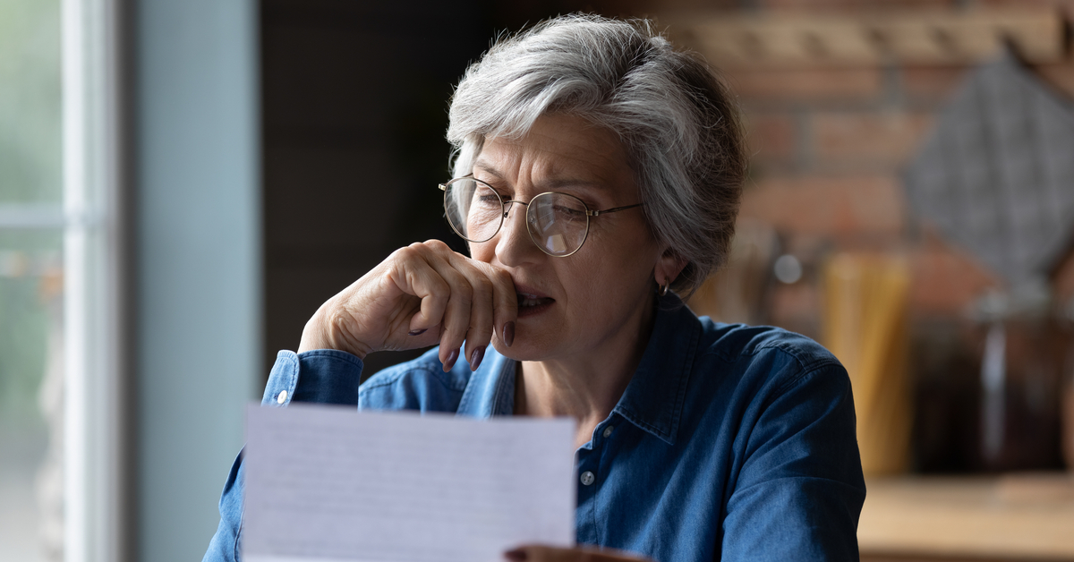 Senior woman looking concerned at paperwork