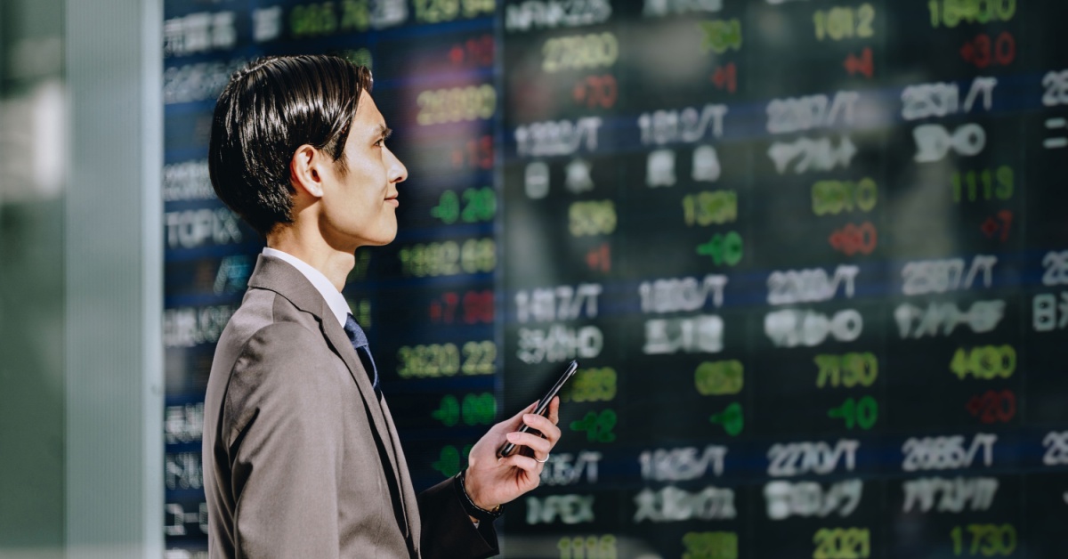 A man looking at a stock board