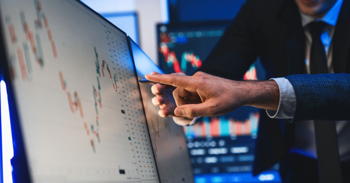 Two traders looking at an index on a computer