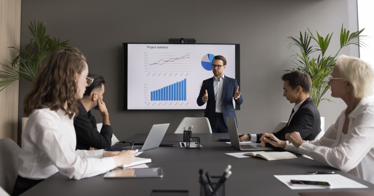 CEO presenting data to a team sitting around a table