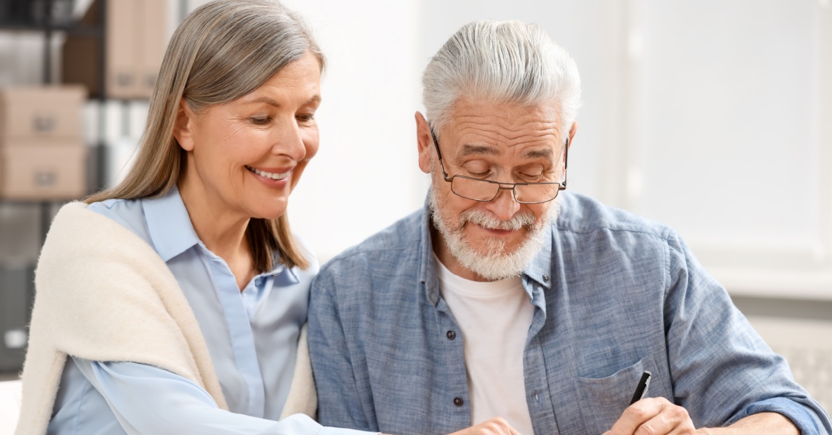 An older couple signing a document