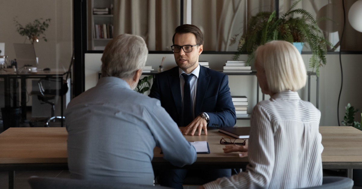 An older couple talking to a younger man.