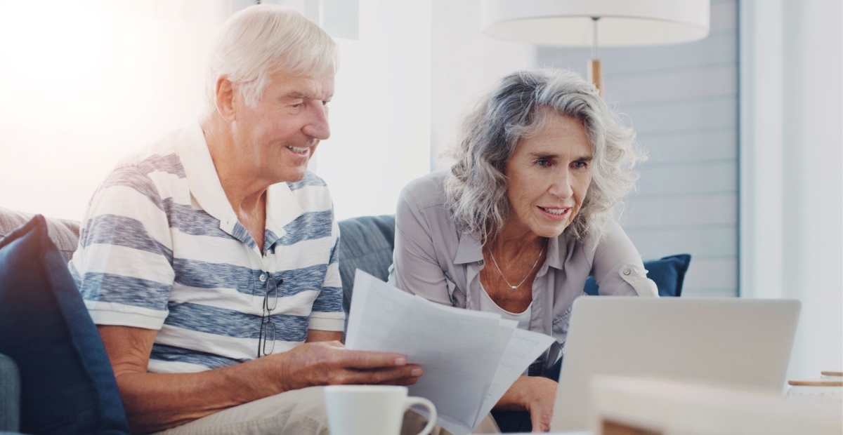 An older couple sitting at a computer together