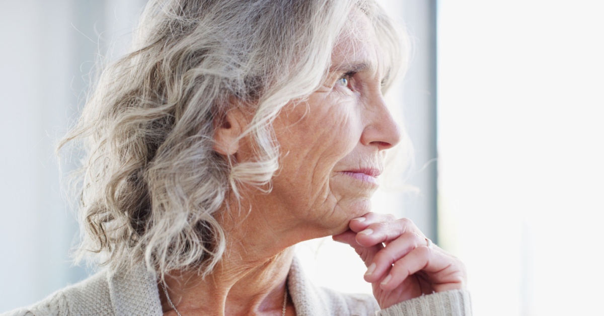 An older woman looking out of a window.