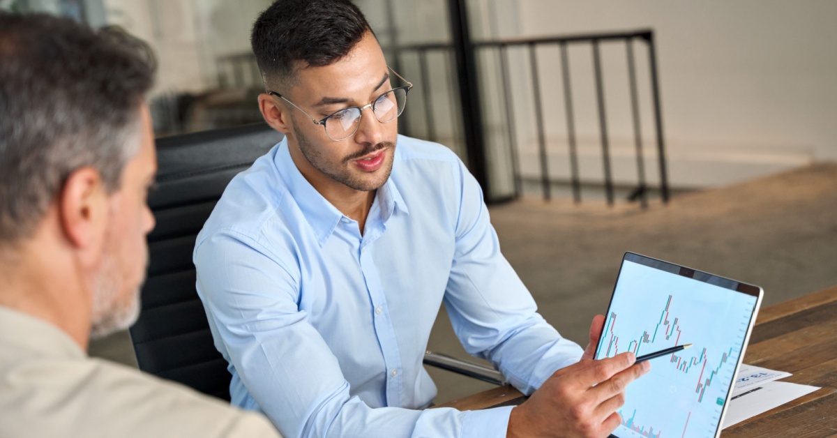 Two investors looking at an index screen.